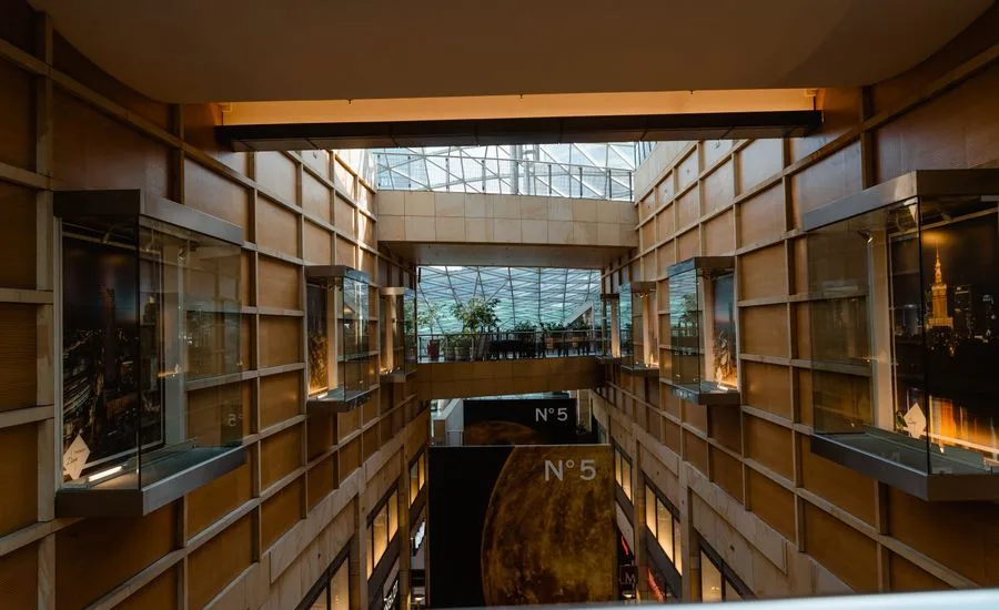Modern commercial building atrium with wooden shelving, glass display cases and skylights
