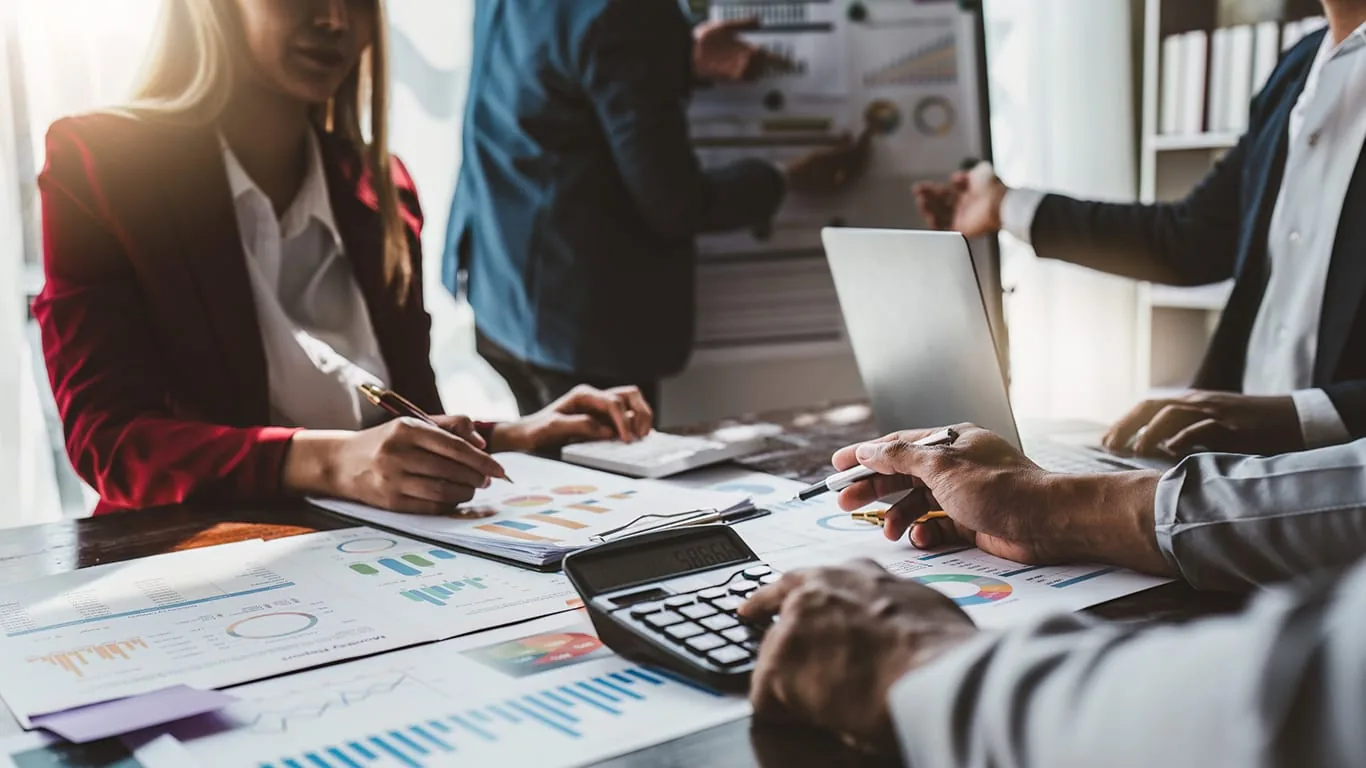 Accountants reviewing financial charts and depreciation schedules around a conference table