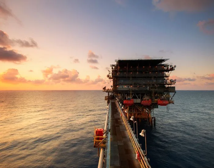 Offshore oil and gas platform at sunset on a calm sea